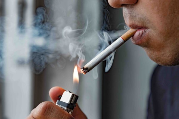 man lighting a cigarette to smoke